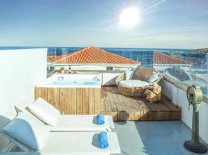a balcony with a table and chairs and a pool at Castel Abaso Boutique Apartments by Explore Andros in Andros