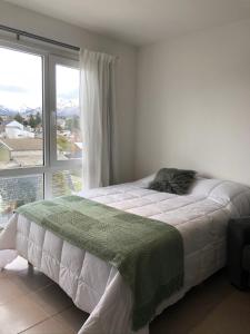1 dormitorio con cama y ventana grande en BettyStudio, cálido, centrico c/ vista a los Cerros en San Carlos de Bariloche