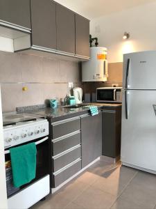 una cucina con piano cottura e frigorifero bianco di BettyStudio, cálido, centrico c/ vista a los Cerros a San Carlos de Bariloche