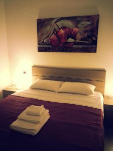 1 dormitorio con 1 cama con una pintura en la pared en Appartamento B&B Suite Stefanelli, en Taranto