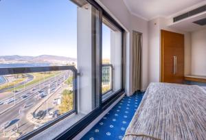 a bedroom with large windows and a view of a highway at Best Western Plus Hotel Konak in Izmir