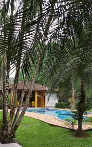里維埃拉德聖洛倫索的住宿－RIVIERA DE SÃO LOURENÇO，棕榈树,在一座带游泳池的房子前