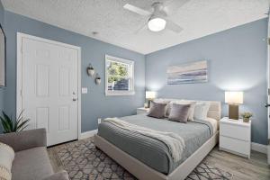 a blue bedroom with a bed and a ceiling fan at Déjà Blue - Steps to the Ocean! in Saint Augustine