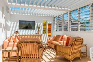 a living room with wicker chairs and a couch at The Terrace Penthouse Apartment in Brunswick Heads