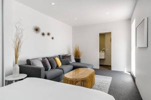 a living room with a couch and a table at The Terrace Penthouse Apartment in Brunswick Heads