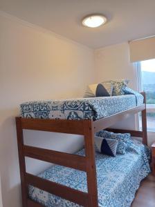 Ce dortoir comprend 2 lits superposés et une fenêtre. dans l'établissement Lomas Papudo 4, à Papudo