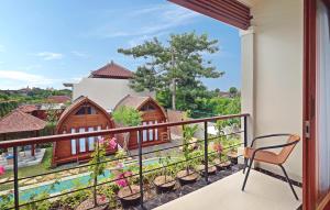 a balcony with a view of a house at Kubu GWK Resort in Jimbaran