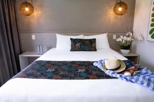 a hotel room with a bed with a hat on it at Castaways Resort & Spa On Mission Beach in Mission Beach