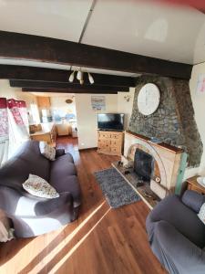 a living room with a couch and a fireplace at Mona Villa Holiday Home in Caulderton