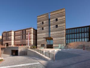 Un grand bâtiment en briques avec un escalier se trouve devant. dans l'établissement Parador de Lorca, à Lorca