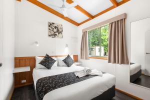 a bedroom with a large bed and a large window at Breeze Holiday Parks - Halls Gap in Halls Gap