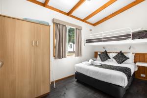 a bedroom with a bed and a dresser at Breeze Holiday Parks - Halls Gap in Halls Gap