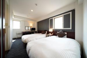 Habitación de hotel con 2 camas y 2 ventanas en Meitetsu Inn Nagoya Ekimae, en Nagoya