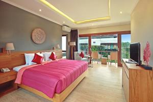 a bedroom with a large bed and a television at Kubu GWK Resort in Jimbaran