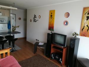 DEPARTAMENTO FRENTE A LA PLAYA 3 personas في فالبارايسو: غرفة معيشة مع تلفزيون وطاولة