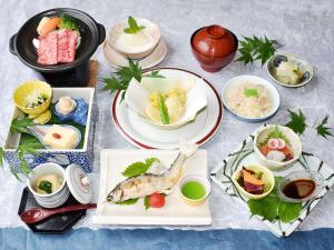 Shiobara Onsen Tokiwa Hotel في ناسوشيوبارا: طاولة مع أطباق من الطعام وأوعية من الطعام