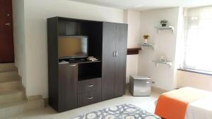 a living room with a television in a cabinet at Casa Prada Bed & Breakfast in Bogotá