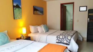 a hotel room with two beds and a mirror at Casa Prada Bed & Breakfast in Bogotá