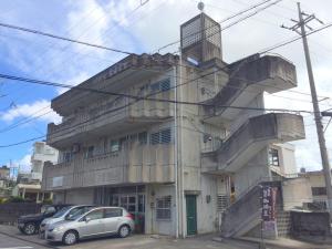 a building with a car parked in front of it at 沖縄ライフインゼファー j28 in Tōbaru