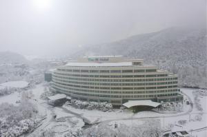 un gran edificio con un cartel en la nieve en The K Hotel Gyeongju, en Gyeongju