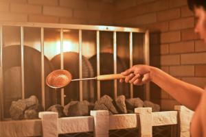 a person cooking in an oven with a spatula at Shinjuku Kuyakusho-mae Capsule Hotel in Tokyo