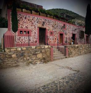 - un bâtiment avec un mur en pierre et un portail dans l'établissement Hotel Hacienda Encantada, à Real de Catorce