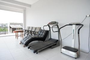 a gym with a treadmill and chairs in a room at RedDoorz Syariah near Kawasan Sam Poo Kong 2 in Kalibanteng-kidul