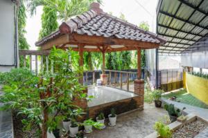 um gazebo com uma piscina num jardim em RedDoorz Syariah near Kawasan Sam Poo Kong 2 em Kalibanteng-kidul