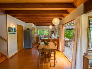 cocina y comedor con mesa y sillas en Secret Garden Lodge - Marahau Holiday Home, en Marahau