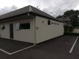 ein großes weißes Gebäude mit Parkplatz in der Unterkunft Hygate Motor Lodge in Hamilton