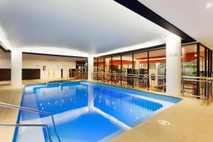 a swimming pool with a large swimming pool in the middle of it at Pullman Melbourne Albert Park in Melbourne