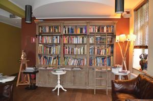 a large wooden book shelf filled with books at Le Presbytère in Differdange