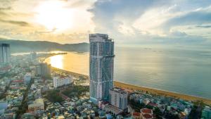 een stad met een hoog gebouw en de oceaan bij TMS Quy Nhơn - RUBY Luxury Apartment in Quy Nhon