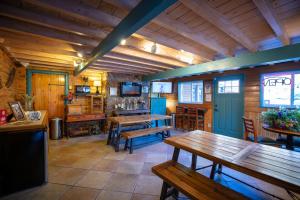 Ouray Inn في أوراي: غرفة مع طاولات وكراسي خشبية في كابينة