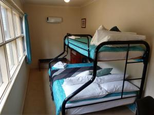 two bunk beds in a room with a window at Cockatoo Cabin in Halls Gap