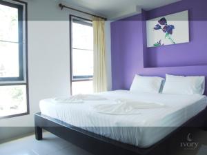 a bedroom with purple walls and a large bed at Ivory Phi Phi Island in Phi Phi Islands