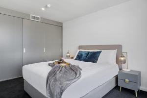 a hotel room with a bed and a dresser at Hobart City Apartments in Hobart