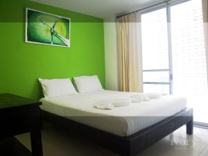 a bedroom with a bed with a green wall at Ivory Phi Phi Island in Phi Phi Don