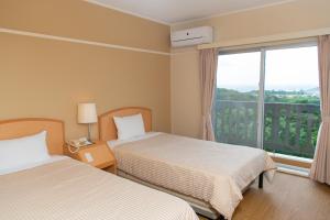 
A bed or beds in a room at Motobu Green Park and Golf Course
