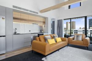 a living room with a couch and a kitchen at Hobart City Apartments in Hobart +20 photos