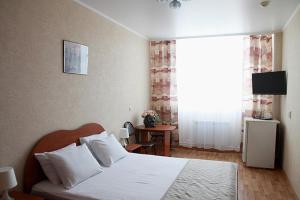 トリヤッチにあるGostinichnyi Kompleks Lada-Voskhodのベッドルーム(白いベッド1台、窓付)