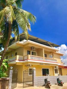 a yellow house with two motorcycles parked in front of it at JMD VILLA in Vagator