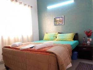 a bed in a bedroom with a blue wall at JMD VILLA in Vagator