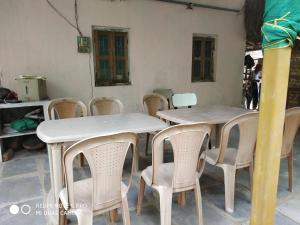 a group of tables and chairs in a room at Suvarna Holiday Home in Kashid