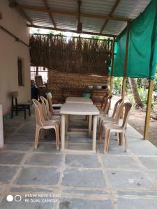 - une table et des chaises blanches sur la terrasse dans l'établissement Suvarna Holiday Home, à Kashid