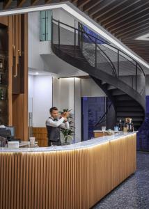 a man taking a picture of a counter with a staircase at Sensory Park Urban Hotel in Phnom Penh +50 photos