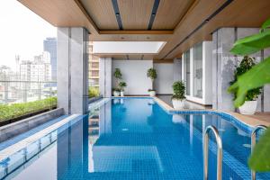 a swimming pool on the roof of a building with plants at Sensory Park Urban Hotel in Phnom Penh