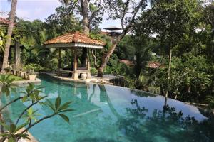 a swimming pool with a gazebo in a garden at The Spice House Mirissa in Mirissa