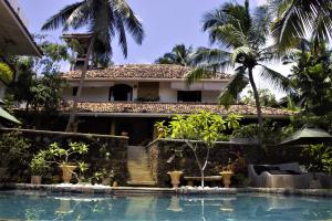 a villa with a swimming pool in front of a house at The Spice House Mirissa in Mirissa