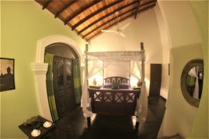 a bedroom with a bed in a room with a door at The Spice House Mirissa in Mirissa